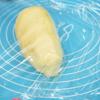 Cho hỗn hợp làm bánh kén đậu xanh ra mặt phẳng có lót tấm nhồi bột chống dính. Tiến hành nhồi bột bánh đậu xanh kén cho mịn. Bọc màng thực phẩm, ủ khoảng 15-20 phút.