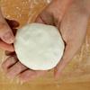 Gói bánh hẹ: Bột sau khi ủ vê dài sau đó chia thành 6 phần bằng nhau, rắc chút bột áo lên thớt rồi cán bột ra thành miếng tròn mỏng khoảng 3mm, cho nhân vào phần giữa bột rồi cuộn lại thành miếng tròn dẹt.