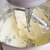 Làm nóng lò nướng ở 180 độ C. Để bắt đầu, cho bơ lạt ở nhiệt độ phòng vào máy trộn đứng và đánh cho tơi mềm. Trút đường vào đánh cùng bơ ở tốc độ trung bình trong khoảng 5 phút cho đến khi hòa trộn đều, mịn và chuyển màu vàng ngà là được. Thêm từng quả trứng vào đánh cũng bơ, đường.