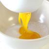 Làm sốt bơ cho bánh tráng bơ tỏi: Cho bơ vào chén nhỏ và đun cách thủy để bơ chảy ra. Trong một cái tô lớn, đánh lòng đỏ trứng với 10gr đường đến khi chuyển sang màu vàng nhạt, tiếp theo cho phô mai vào tán nhuyễn, trộn đều hỗn hợp. Rây từ từ bột bắp vào tô, cho tiếp bơ đã đun chảy và khuấy đều cho các nguyên liệu hòa quyện.